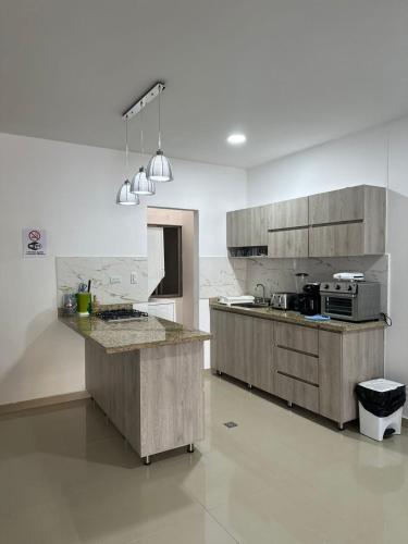 kuchnia z drewnianymi szafkami i blatem w obiekcie Espectacular apartamento central w mieście Montería