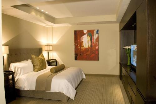 une chambre d'hôtel avec un lit et une télévision dans l'établissement Antaris Cintermex, à Monterrey