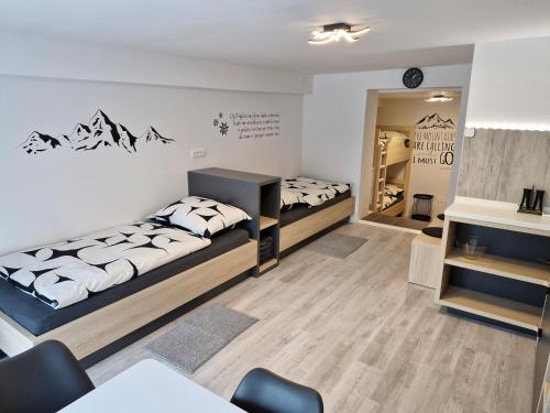 Cette chambre comprend deux lits, une table et des chaises. dans l'établissement Apartma Vovk, à Mojstrana