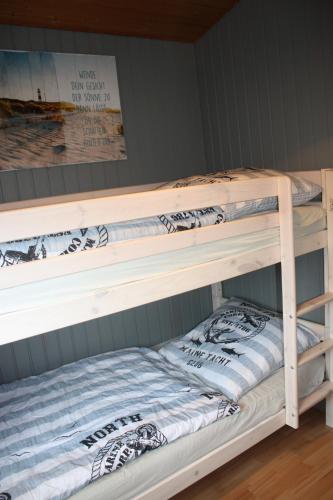 a bunk bed in a room with two bunk beds at Us nige Wark - Familienfreundliches Haus an der Nordsee in Spieka-Neufeld
