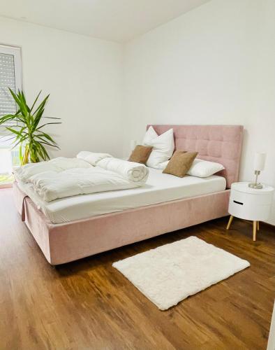 een groot bed in een witte kamer met een tapijt bij Highlight! Stilvolle 100m2 mit Büro Nähe München in Mühldorf