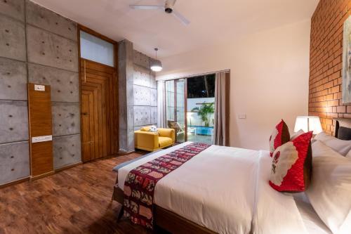 a bedroom with a large white bed with red pillows at Asta in Ooty
