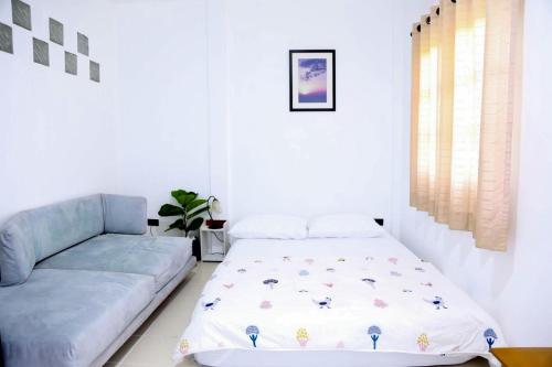a living room with a bed and a couch at Bann Sawasdee Donmueng- Saimai หลังใหญ่ ฟรี wifi in Ban Sai Mai