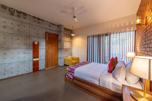a bedroom with a bed and a large window at Asta in Ooty