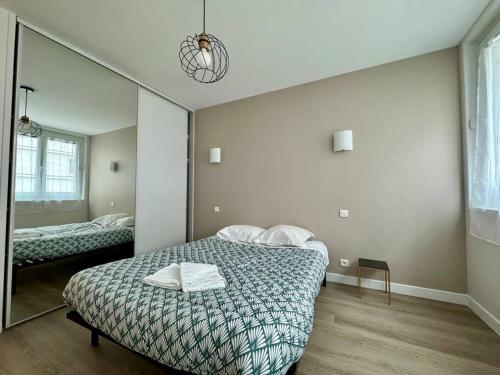 a bedroom with a bed and a large mirror at F3 Plein Cœur Centre Clermont FD avec Parking Montrognon in Clermont-Ferrand