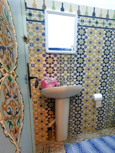 a bathroom with a sink and a window at Casa Plasa Grande chefchaouen in Chefchaouene