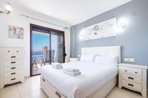 ベニドルムにあるTorre Mar 20-F Apartment Levante Beachの海の景色を望むベッドルーム1室(白いベッド1台付)