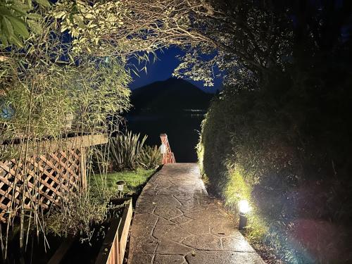a walkway with a view of a lake at night at Private Room On Waterfront Property With Hot Tub & Firepit - Sea Esta in Ucluelet