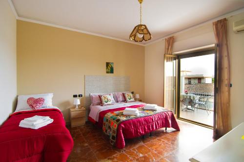 1 dormitorio con 2 camas, mesa y balcón en Casa Aurora en Giarre