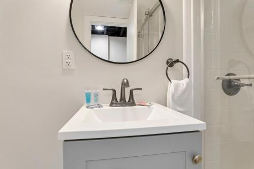 uma casa de banho branca com um lavatório e um espelho em The Blue Beechwald Bungalow em Columbus