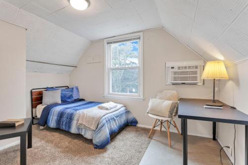um quarto com uma cama, uma secretária e uma janela em The Blue Beechwald Bungalow em Columbus