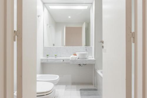 Baño blanco con aseo y lavamanos en Fliphaus Zapiola 2300 - Lux Aparts 'a' Belgrano en Buenos Aires
