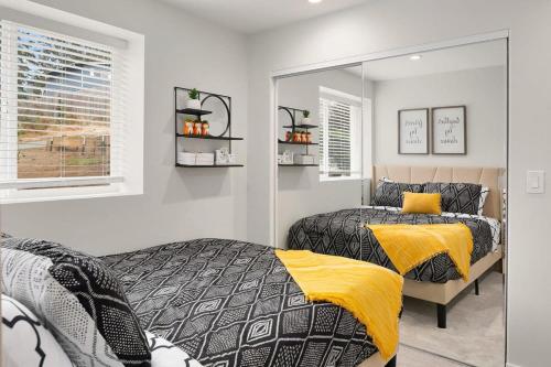 a bedroom with two beds and a mirror at Brand New Designer's Modern 1BR Home 1min to I-5 in Lynnwood