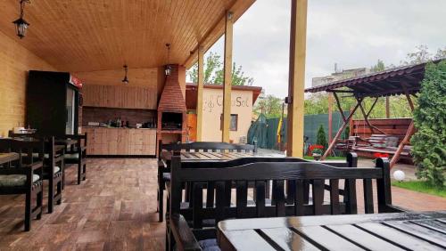 un patio con tavoli e sedie in legno e una cucina di Casa SOL a Turda