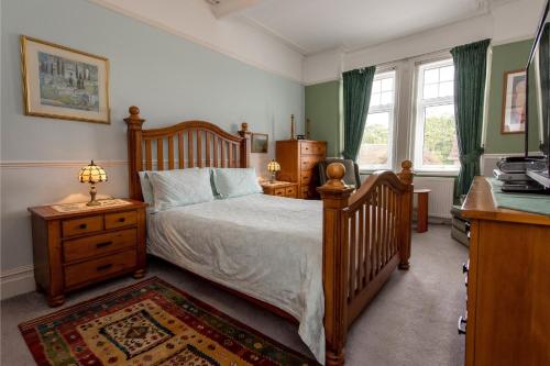 1 dormitorio con 1 cama, vestidor y escritorio en The Strand Hotel, en Bournemouth