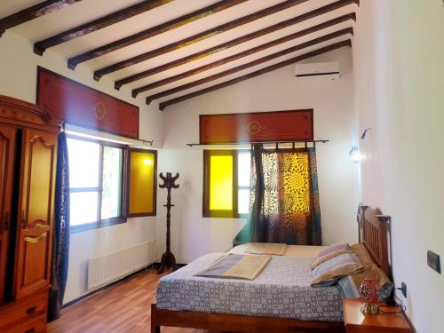a bedroom with a bed and two windows at Riad Casa Youssef in Chefchaouene