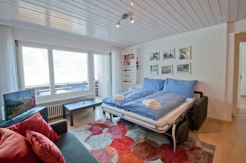 a bedroom with a bed and a living room at Haus Arola, Apartment Hirle in Zermatt