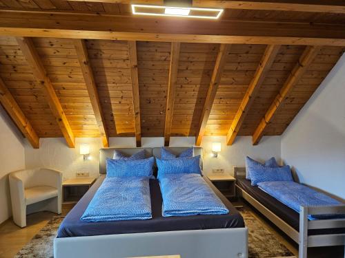 2 Betten in einem Zimmer mit Holzdecken in der Unterkunft Gästehaus Rana in Rust