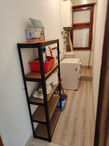 a room with a shelf and a room with a kitchen at Casa di Gino in Pontedera