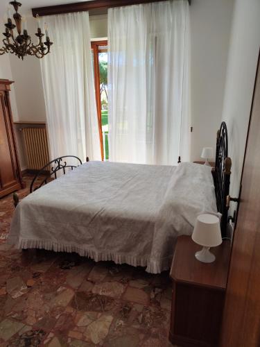 a bedroom with a large bed and a window at Casa di Gino in Pontedera
