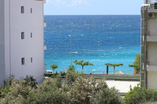 a view of the ocean from between two buildings at Stef & Stam Nerantzis in Himare