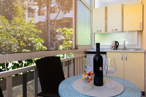a table with a bottle of wine and two glasses at Apartmani Tona in Gradac