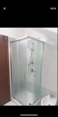 La salle de bains est pourvue d'une douche en verre et d'un lavabo. dans l'établissement Suite Room Malpensa apartment, à Cardano al Campo