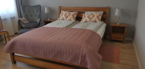 ein Schlafzimmer mit einem großen Bett und einem Stuhl in der Unterkunft Apartamenty Po Kominiarzach in Chełmno