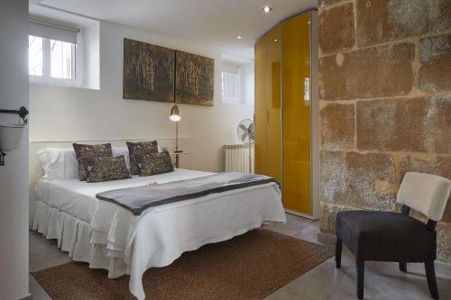 a bedroom with a bed and a stone wall at pilliku apartamentua garaje incluido in Orio