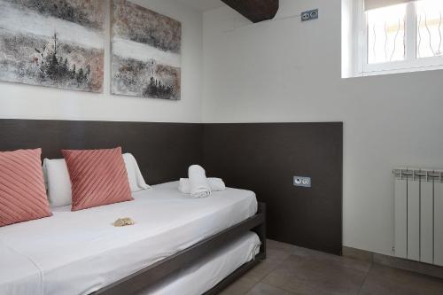 1 dormitorio con 1 cama con almohadas rojas y blancas en pilliku apartamentua garaje incluido, en Orio