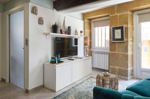 a kitchen with white cabinets and a blue couch at pilliku apartamentua garaje incluido in Orio