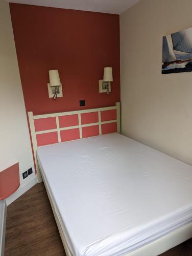 Ce lit se trouve dans un dortoir doté de 2 lumières sur le mur. dans l'établissement Appartement les Parcs de Grimaud golfe de St TROPEZ , avec une chambre, à Grimaud