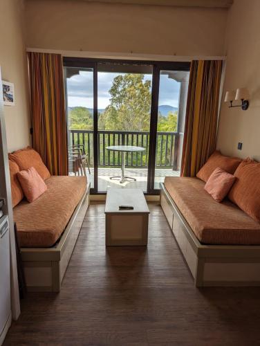 - un salon avec 2 lits et un balcon dans l'établissement Appartement les Parcs de Grimaud golfe de St TROPEZ , avec une chambre, à Grimaud