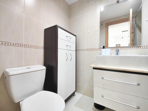 ein Badezimmer mit einem WC, einem Waschbecken und einem Spiegel in der Unterkunft Appartement Peniscola, 3 pièces, 4 personnes - HISP-234-121 in Peñíscola
