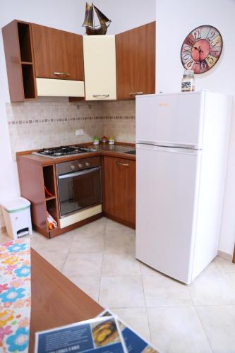uma cozinha com um frigorífico branco e armários de madeira em Politeama guest house Palermo Mimosa em Palermo
