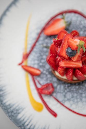 a plate topped with strawberries and fruit on a table at Hôtel La Plage 5 étoiles La Grande Motte in La Grande-Motte
