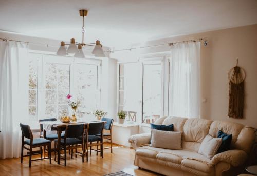 ein Wohnzimmer mit Sofa, Tisch und Stühlen in der Unterkunft Sielanka Dom nad Morzem in Sławoszyno