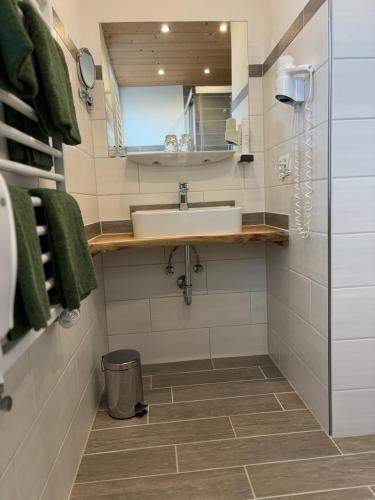 a bathroom with a sink and a mirror at Pension Bavaria in Mittenwald