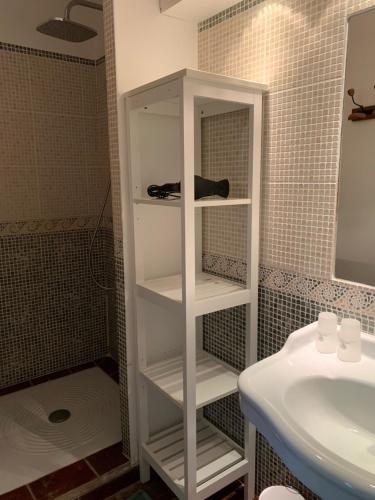 um armário branco numa casa de banho ao lado de um lavatório em Li Poulidetto em Lioux