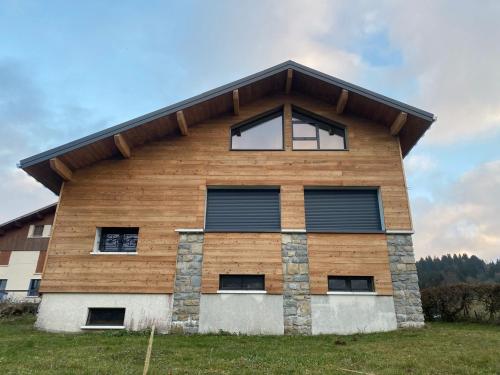 a wooden building with a gambrel roof at Chalet Le Bisolet in Les Déserts