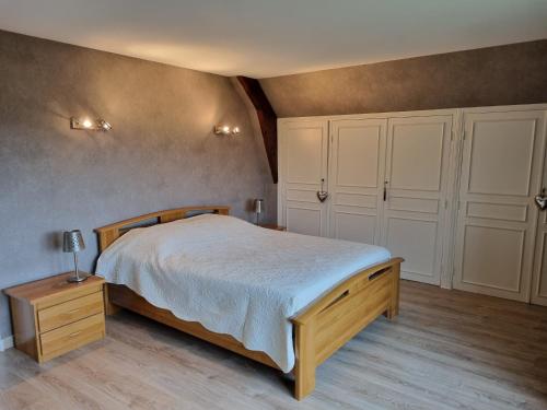 een slaapkamer met een groot bed en witte kasten bij Vaucelles city in Vaucelles