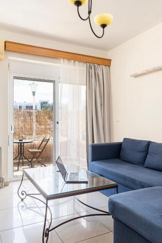 a living room with a blue couch and a glass table at Seascape in Kos Central in Ampavris