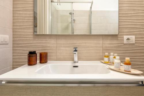 a white sink in a bathroom with a mirror at Luxury Sofia Home Alghero in Alghero
