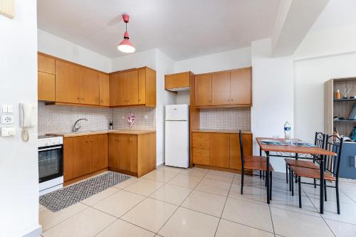 a kitchen with a table and a white refrigerator at The Retreat in Kos Central in Ampavris