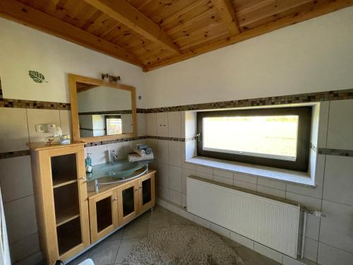 ein Bad mit einem Waschbecken und einem Fenster in der Unterkunft Villa Kronsteert in Dahme