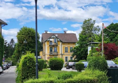 a yellow house on the side of a street at Loft Barbara in Velden am Wörthersee