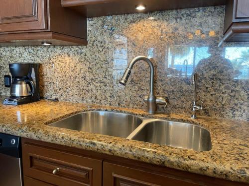 Un fregadero de acero inoxidable en una cocina con encimeras de granito. en Sonoran Sky 203 Spacious Elegant Beauty, en Puerto Peñasco