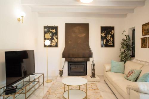 White Star Estoril في استوريل: غرفة معيشة مع أريكة ومدفأة