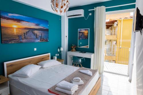 a bedroom with a bed with a blue wall at Stef & Stam Nerantzis in Himare