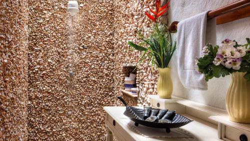 a bathroom with a shower with a mosaic wall at Casa de São José Hotel Boutique in Camocim
